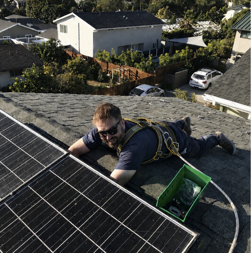 Kody inspecting a rooftop solar array